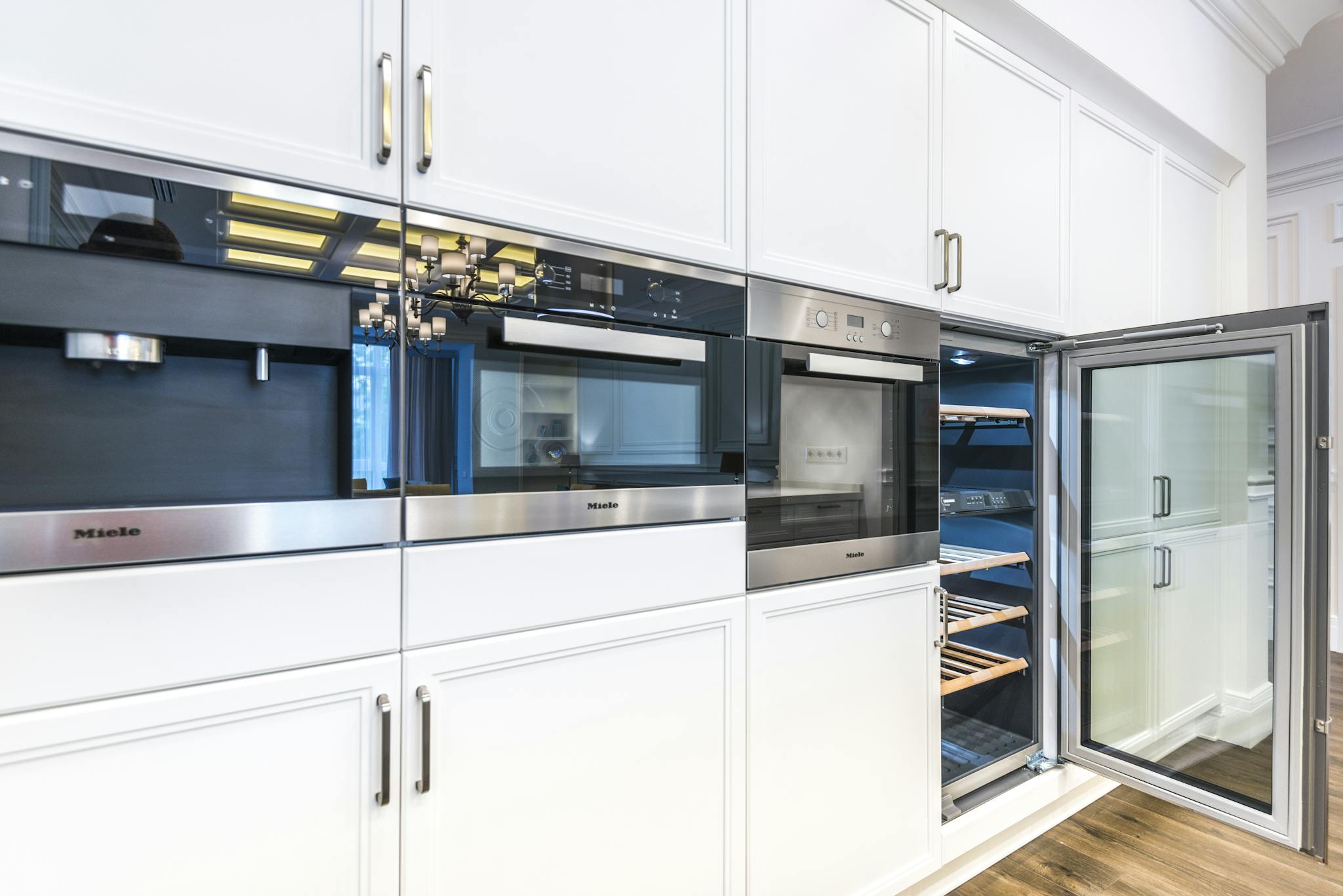 A sleek contemporary kitchen featuring built-in appliances and minimalist white cabinets for a spacious look.